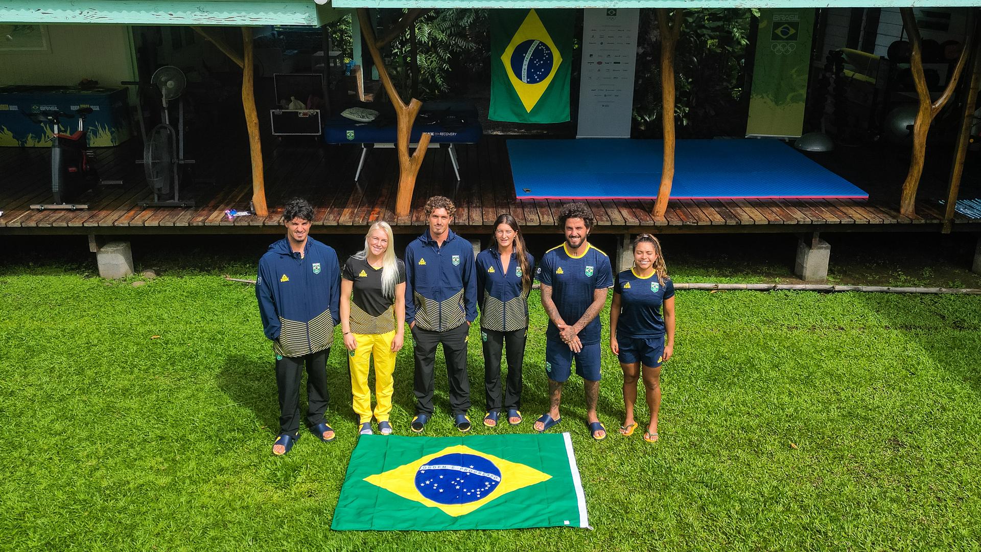 Surfistas brasileiros já chegaram ao Taiti para os Jogos Olímpicos - Foto: William Lucas/COB Surfistas brasileiros posam com a bandeira do Brasil